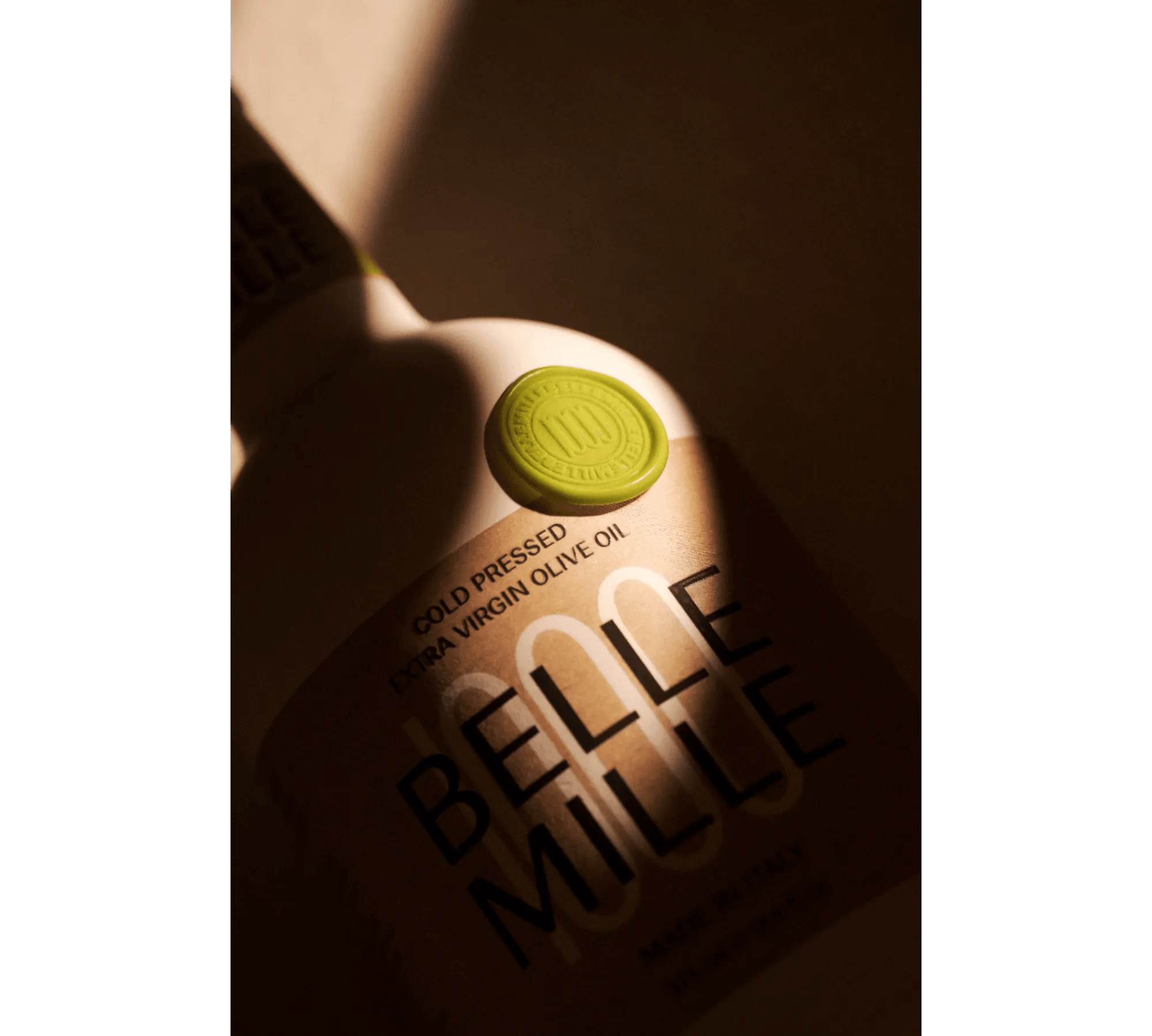 Bottle with a green cap and label reading 'BELLE MULE' and 'good pressed' with olive oil text.