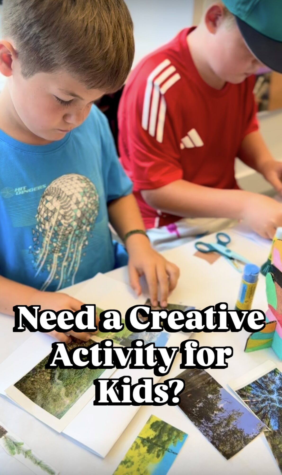 Two children engaged in a creative activity with paper, scissors, and colorful supplies on a table.
