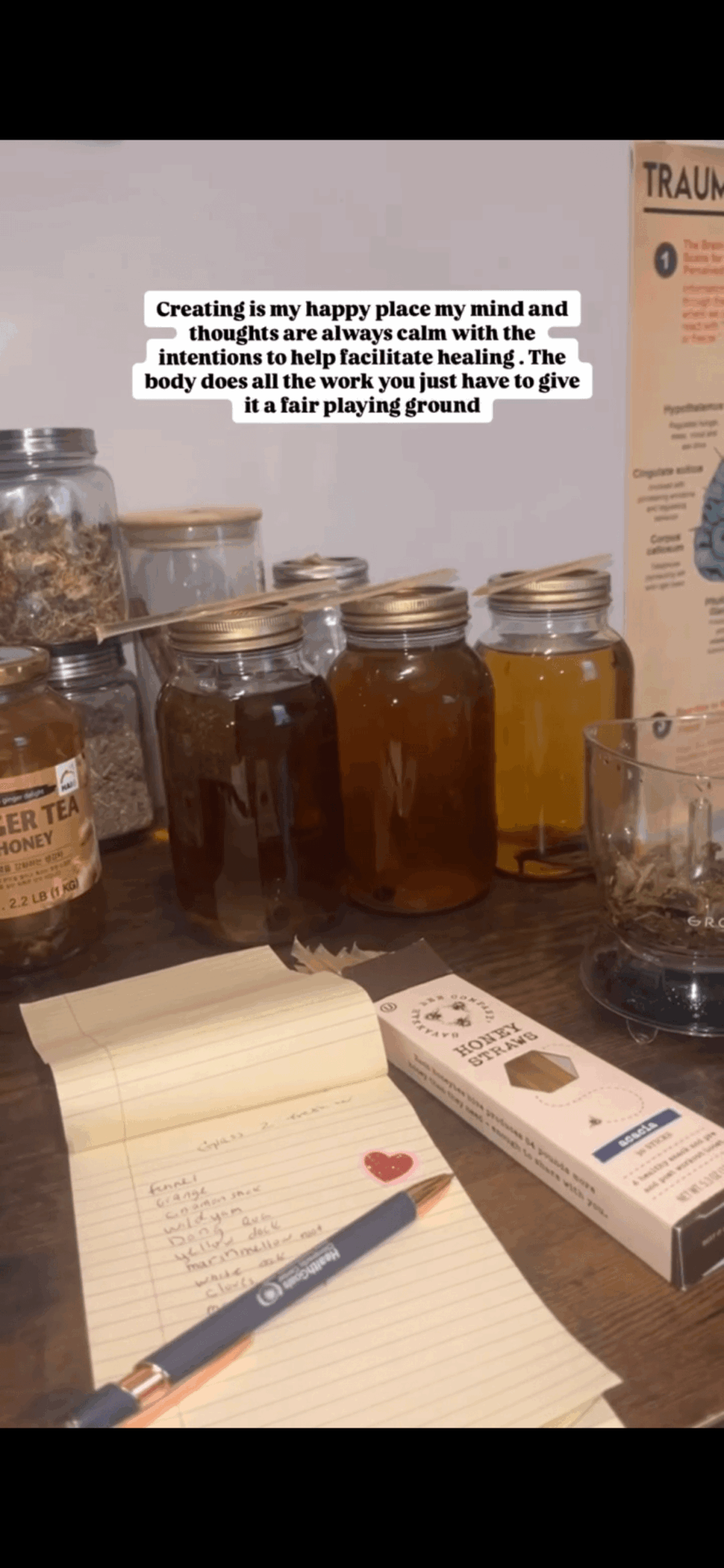 Jars of honey, a notepad with a pen, and a box of medical supplies on a table.