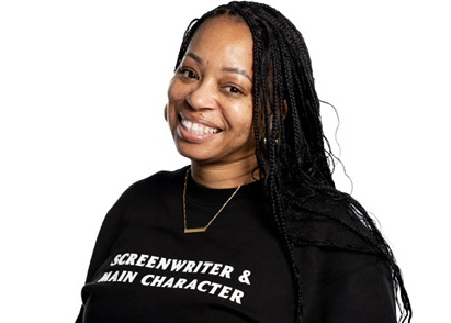 Smiling woman with long braided hair wearing a black shirt with white text, against a white background.