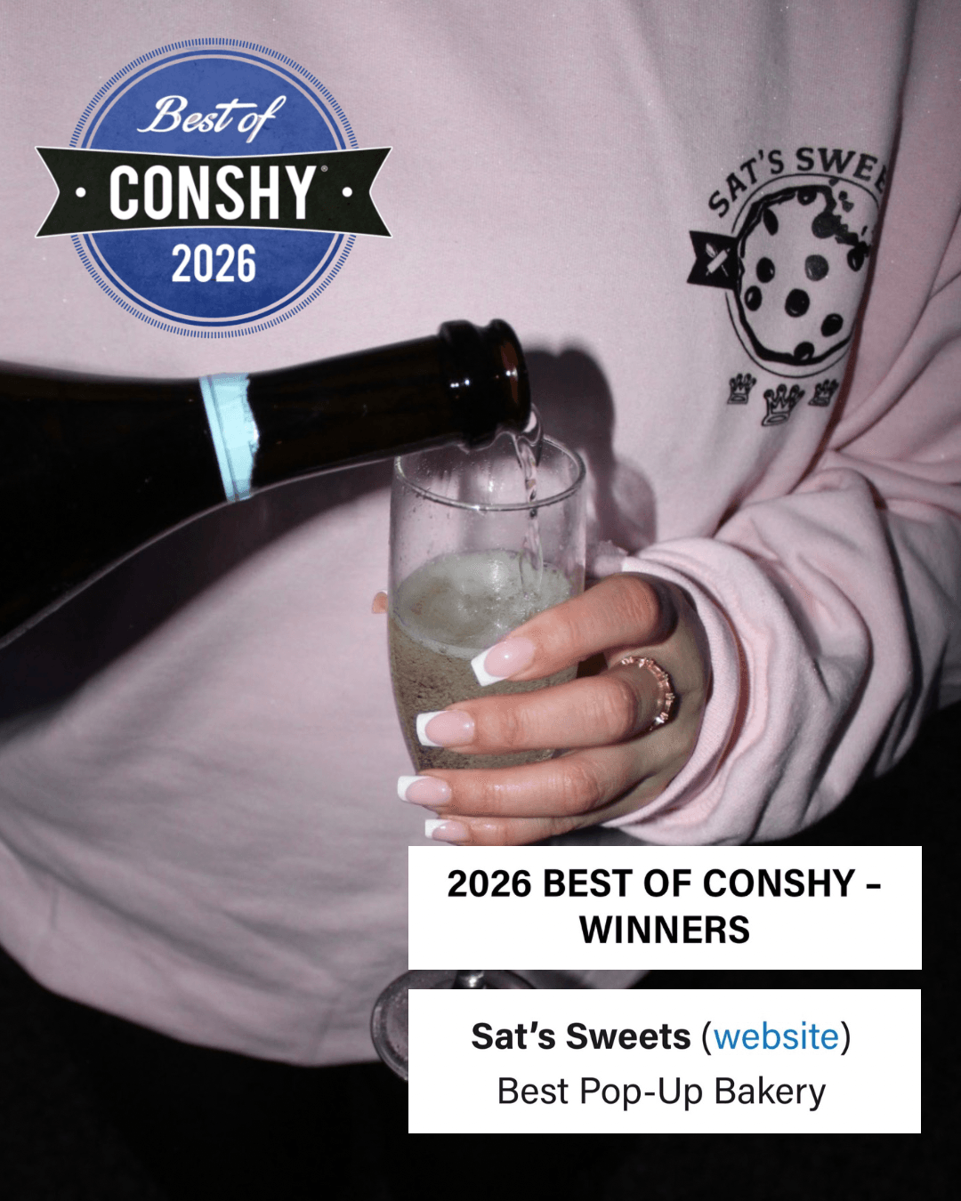Person pouring a beverage into a glass, wearing a pink hoodie with a bakery logo, holding a gold ring, with a badge reading 'Best of CONSHY 2026'.